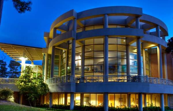 Exterior of Mobile Museum of Art. Large, round building with walls made of glass.