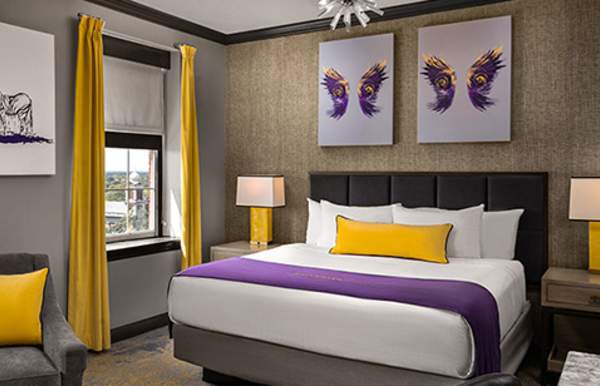 Hotel room bed, two framed artwork of wings above the bed