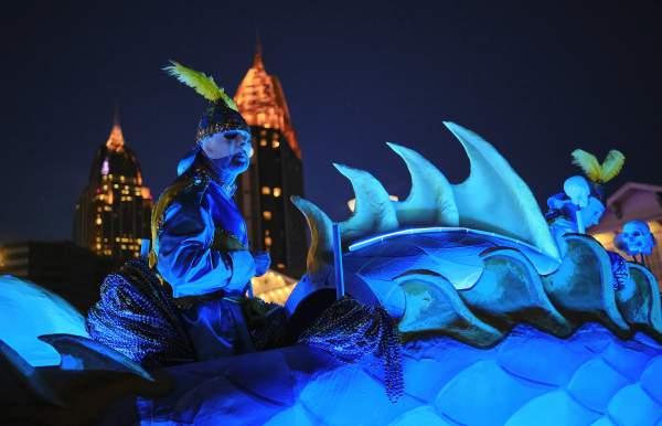 Masked man riding Mardi Gras float
