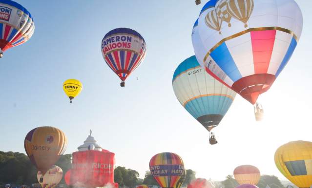 A group of balloons lifting off in a mass ascent at Bristol International Balloon Fiesta - credit Paul Box