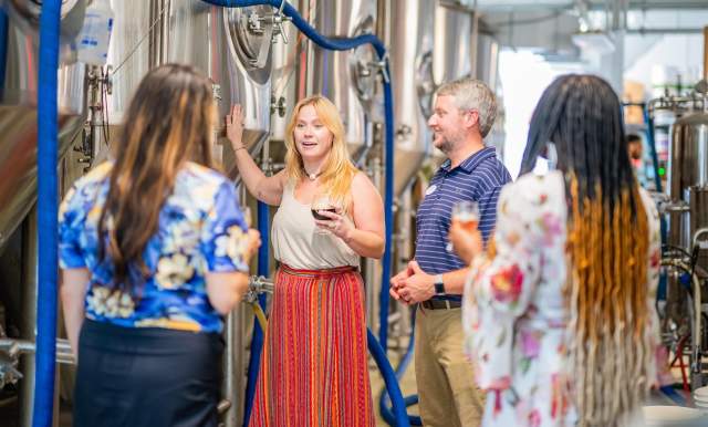 A woman guides a group through a brewery