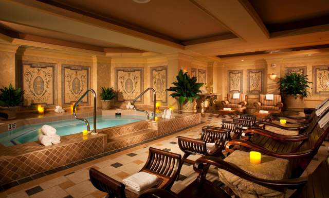 room with indoor pool and wooden chaise lounges