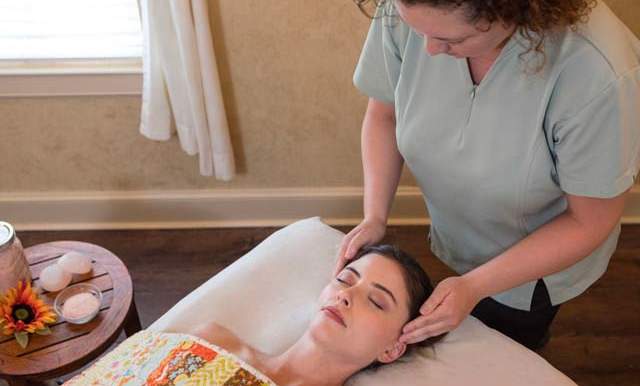 Masseuse rubbing woman's head