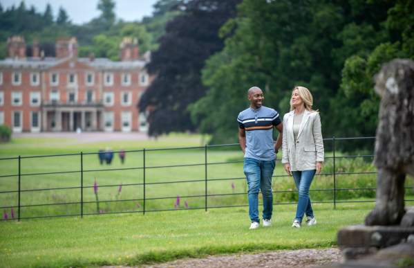 couple walking the grounds with the House in the background