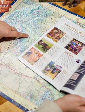 Person observing a map, pointing towards locations.