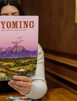 Person holding and reading the official printed Travel Guide