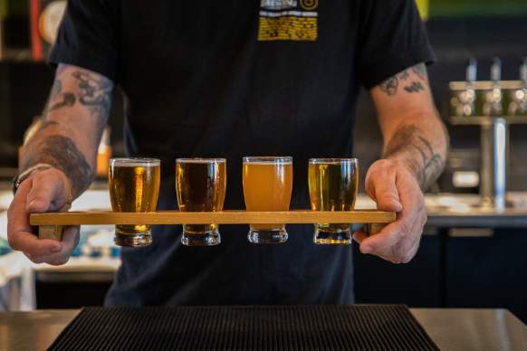 Bartender carrying a flight of beer at a local brewery in Temecula