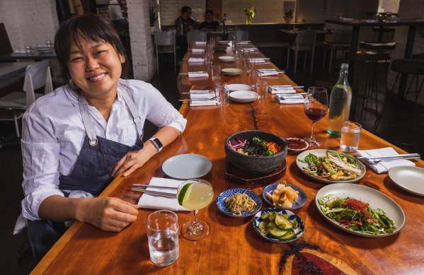Chef Ji Hye Kim at a table of Korean food
