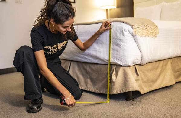 Woman measuring hotel bed for Wheel the World