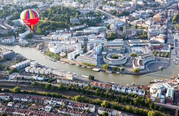 An aerial view of hot air balloons flying over Bristol Harbourside