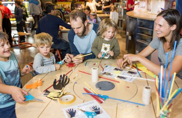 Family trying the bionic hands activity at We The Curious Bristol - credit Paul Blakemore