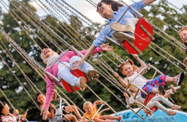 Children riding on a swing ride at Bristol International Balloon Fiesta - Credit Paul Box