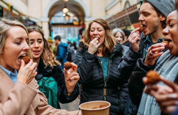 A group of people tasting food in St Nicholas Market on the Bristol Food Tour - credit Yuup