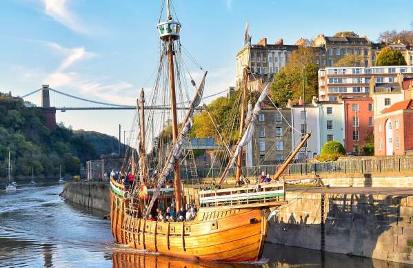 A view of The Matthew replica ship passing through Bristol's Cumberland Basin with the Clifton Suspension Bridge in the background - credit Nick Greville