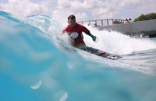 A surfer taking part in adaptive surfing at The Wave inland surfing lake near Bristol - credit The Wave