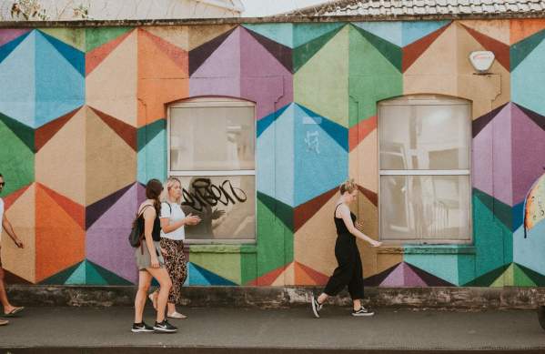 A tour guide leading a group past artworks painted during the Upfest street art festival in South Bristol