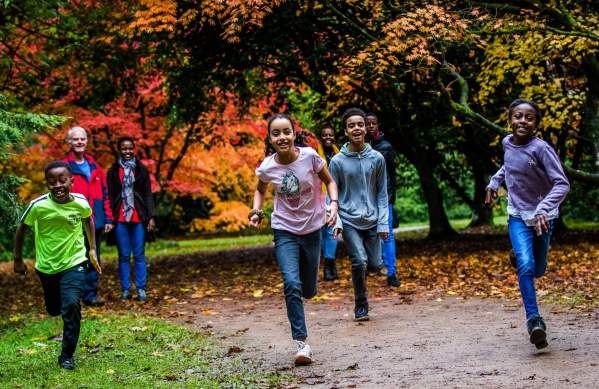 A family running through the grounds of Westonbirt Arboretum near Bristol in autumn - credit Johnny Hathaway