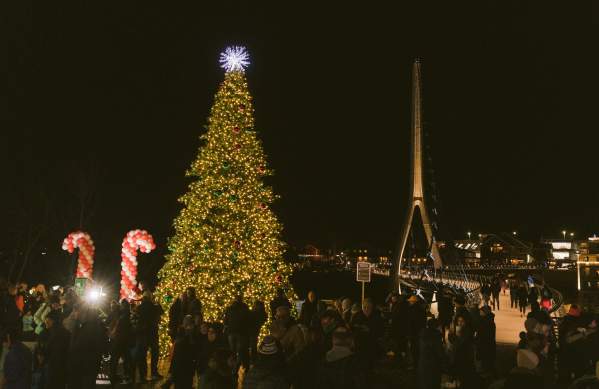 A giant Christmas tree lit up in front of the Dublin Link pedestrian bridge at night in Riverside Crossing Park