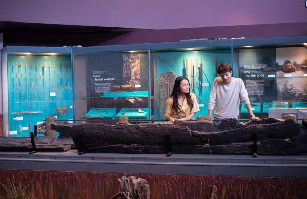 A couple look at the remains of a Roman boat in the Lincoln Museum