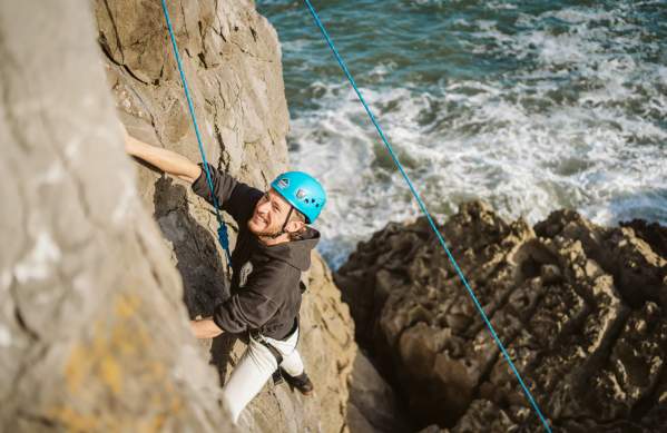 Man abseiling along coastal cliffs
