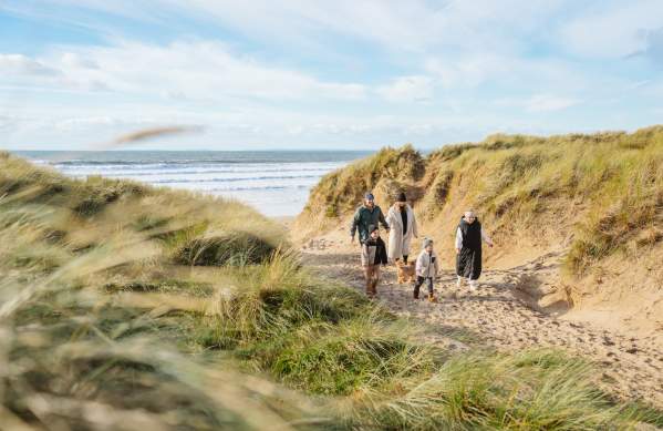 A family taking a walk with their dog on the beach