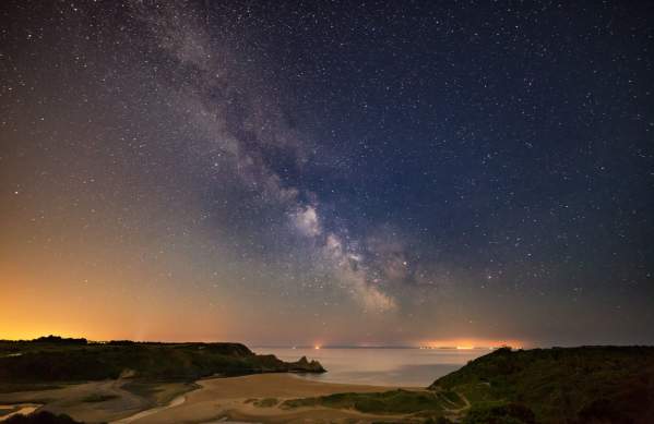 Three cliffs coastline at night with sky full of stars