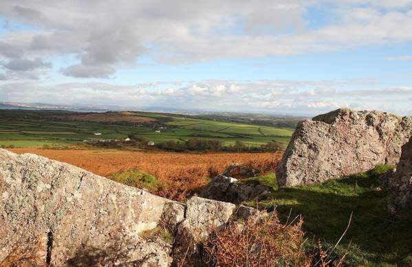Rural Gower landscape with a rock formation in the foreground.