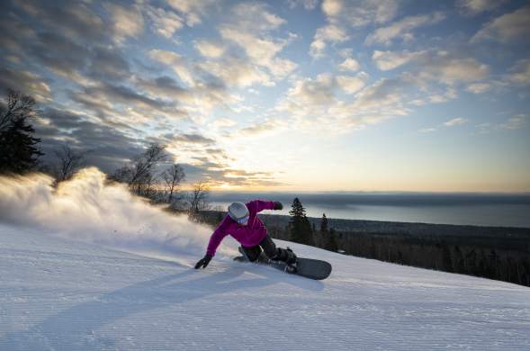 Snowboarder with Lake Superior in background at Lutsen Mountains