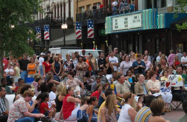 Crowd Of People Sitting In Front Of A Theatre
