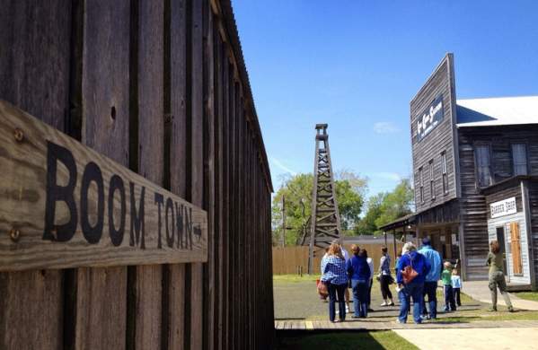 Boom Town sign with group and Spindletop in the background