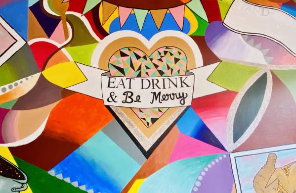 The colorful mural at Stir It Up advises patron to "Eat, Drink, & Be Merry."