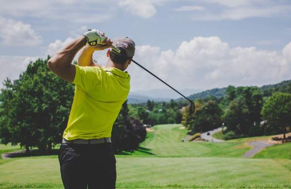 Man taking a golf swing at a golf course in Beaumont, TX