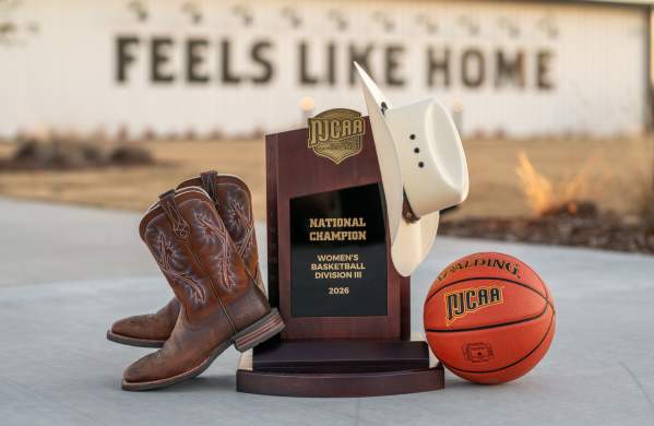 NJCAA Trophy decorated with boots, a cowboy hat, and the game ball outside of the Brownwood Event Center
