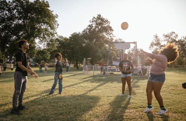 Group of people enjoying the fun in the park event at Cecil Holman park with rides in the back ground
