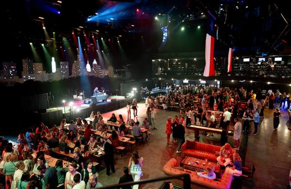 Interior of ACL Live venue with attendees of CEMA Summit at tables, couches and standing while networking