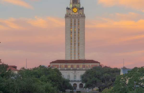 Sun setting behind the iconic UT Tower at the University of Texas at Austin.