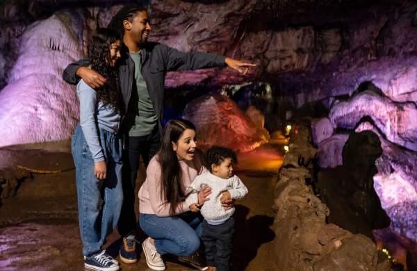 A family in a cave at Wookey Hole in Wells, near Bristol - credit Wookey Hole
