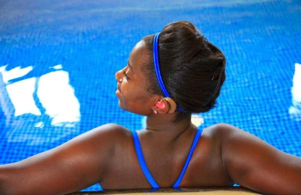 Profoundly deaf woman with hearing aids relaxing in the swimming pool at Ellwood Cottages, Woolland, Dorset. Credit VisitBritain Pawel Libera Tourism For All