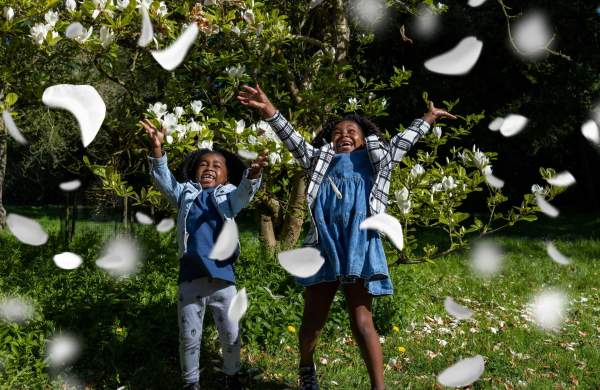 Children playing in flower blossom at Westonbirt Arboretum near Bristol among spring blossom - credit Johnny Hathaway