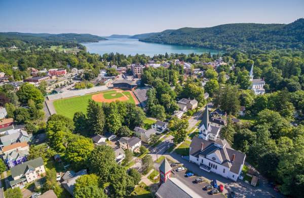 An aerial photo of then Village of Cooperstown during summer with a baseball field and lake.
