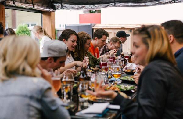 People at long table getting together at local restaurant to share meal