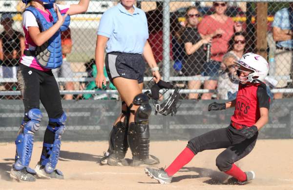 Softball player sliding into base at one of Evergreen Park's ball diamonds