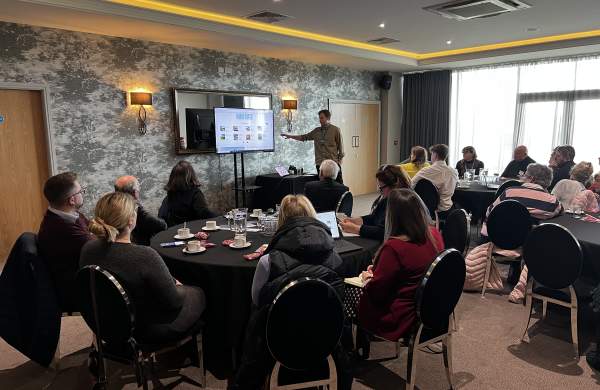 A networking event with man presenting from screen