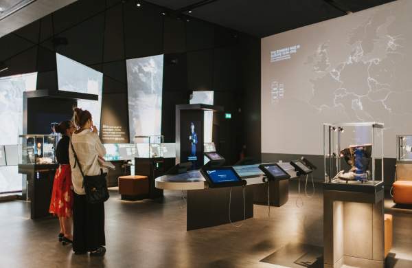 two people stood in a large indoor exhibition space with screens and displays