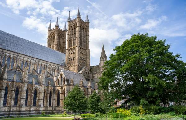 A cathedral surrounded by trees and bushes under blue skies