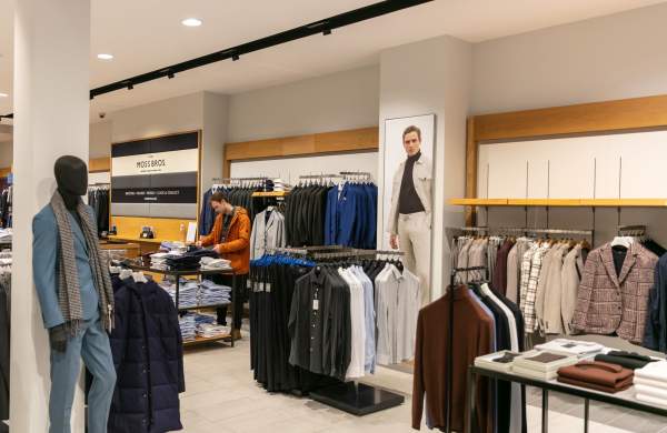 interior of a men's clothing store with mannequins and suits on racks