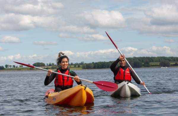 Two people in kayaks on a lake in Rutland, Lincolnshire