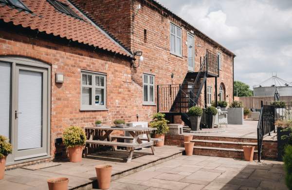 Accommodation exterior with picnic benches and plants