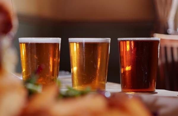 A close up image of three pints of beer inside a pub