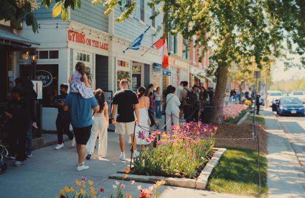 Crowd walking on sidewalk in front of heritage shops